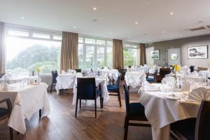 a dining room with tables and chairs with white tablecloths at Budock Vean Hotel in Falmouth