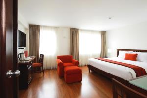 Habitación de hotel con cama y silla en San Agustin Exclusive, en Lima