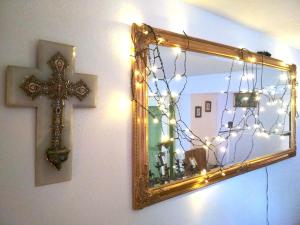 a mirror and a cross on a wall with lights at Grüne Franziska in Ettenheim