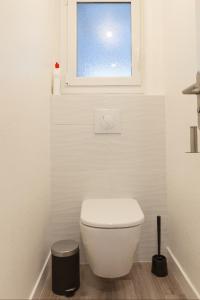 bagno con servizi igienici bianchi e finestra di Appart Center Bara a Brest