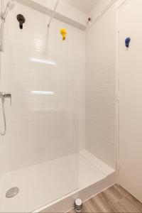 una doccia bianca con porta in vetro in bagno di Appart Center Bara a Brest