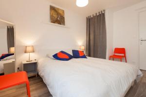 una camera con un letto bianco e due sedie rosse di Appart Center Bara a Brest