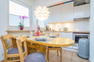 eine Küche mit einem Holztisch und Stühlen in der Unterkunft Perfekte Wohnung in perfekter Lage mit Balkon! in Westerland