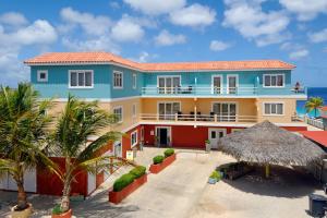 a house on the beach with palm trees at Oceanfront Tarpon at Den Laman in Kralendijk