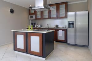 a kitchen with a stainless steel refrigerator and cabinets at Oceanfront Tarpon at Den Laman in Kralendijk