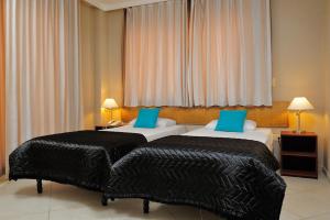 a hotel room with two beds and a window at Oceanfront Tarpon at Den Laman in Kralendijk