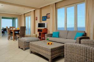 a living room with a couch and chairs and a television at Oceanfront Tarpon at Den Laman in Kralendijk