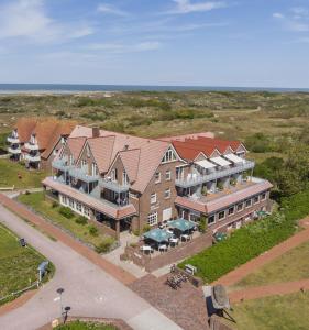 an aerial view of a large building with the ocean at Hotel Strandhof in Baltrum