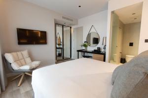 a bedroom with a white bed and a chair at Old Port Hotel in Limassol
