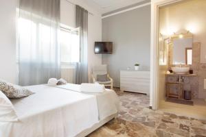 1 dormitorio con 1 cama blanca grande y espejo en Salento Inside, en Morciano di Leuca