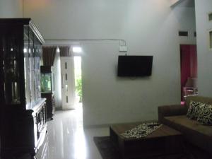 a living room with a couch and a flat screen tv at Kartika Guest House Cianjur in Tjiandjur