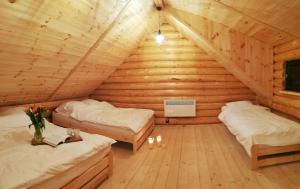Habitación con 2 camas en una cabaña de madera en Zalesie - wyjątkowe domki nad jeziorem, en Zalesie
