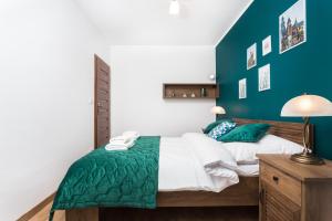 sypialnia z łóżkiem z zielonym akcentem w obiekcie City of the Kings - Wolf Apartment w Krakowie
