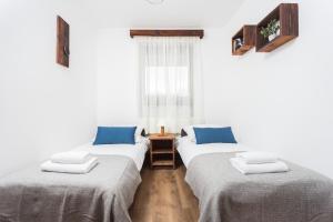 two twin beds in a room with a window at City of the Kings - Wolf Apartment in Krakow