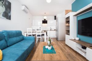 a living room with a blue couch and a kitchen at City of the Kings - Wolf Apartment in Krakow