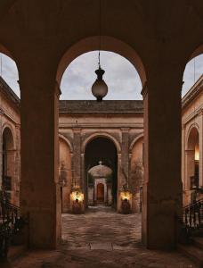 un arco en un edificio antiguo con una lámpara en Palazzo Daniele, en Gagliano del Capo