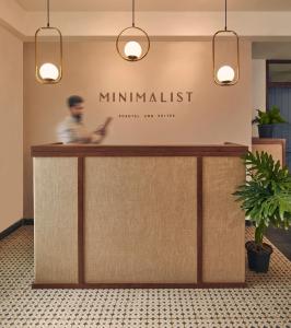a man standing behind a counter in a lobby at Minimalist Poshtel & Suites in New Delhi