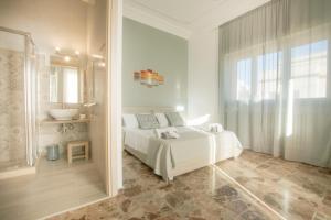 a bedroom with a white bed and a bathroom at Salento Inside in Morciano di Leuca