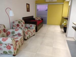 una sala de espera con 2 sillas y un sofá en EN EL CORAZON DE MI BELLO SAN JUAN en San Juan