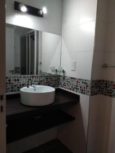 a bathroom with a white sink and a mirror at EN EL CORAZON DE MI BELLO SAN JUAN in San Juan