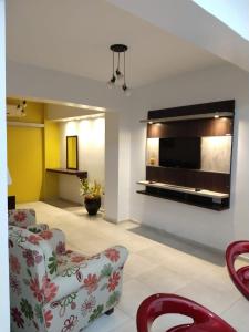 sala de estar con 2 sillas y TV en la pared en EN EL CORAZON DE MI BELLO SAN JUAN en San Juan
