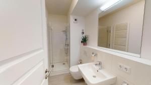 a bathroom with a sink and a toilet and a mirror at Südkap E-04 in Pelzerhaken +36 photos