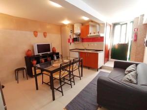 a living room with a table and a kitchen at Casa da Avó in Elvas