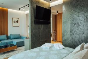 Alice Place Hotel في أوديسا: غرفة معيشة مع سرير وتلفزيون على جدار