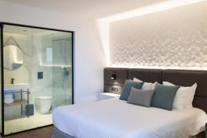 a bedroom with a large white bed and a shower at Old Port Hotel in Limassol