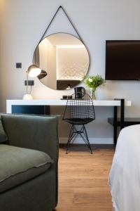 a room with a desk with a mirror and a couch at Old Port Hotel in Limassol