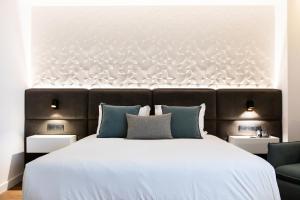 a bedroom with a large white bed with blue pillows at Old Port Hotel in Limassol