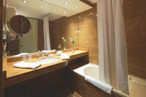a bathroom with a sink and a tub and a mirror at San Agustin Exclusive in Lima