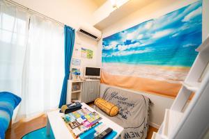 Kataseにあるレベアス片瀬江ノ島WESTのベッド、デスク、テーブルが備わる小さな客室です。