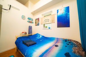 a bedroom with a blue bed in a room at レベアス片瀬江ノ島WEST in Katase