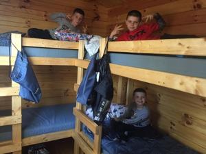 three boys laying in bunk beds in a cabin at Anvil Campground in Williamsburg