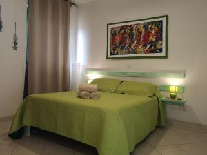 a bedroom with a green bed with two towels on it at Ca' Teresa in Santa Maria