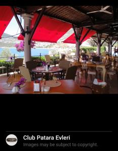 a restaurant with tables and chairs and red umbrellas at Seaview holiday home in Kalkan