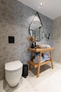 a bathroom with a white toilet and a mirror at Old Port Hotel in Limassol