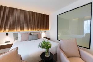 a bedroom with a white bed and two chairs at Old Port Hotel in Limassol