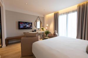 a hotel room with a white bed and a living room at Old Port Hotel in Limassol