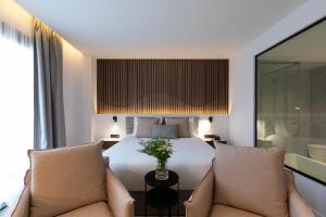 a hotel room with a bed and two chairs at Old Port Hotel in Limassol