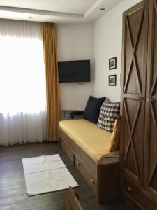 a small bedroom with a bed and a television at Guest Rooms Boutique Varna in Varna City