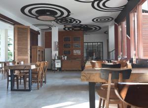 uma sala de jantar com mesas e cadeiras e um tecto em Mom's Corner em Malang