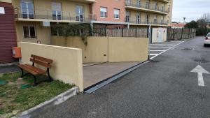 a bench sitting next to a wall next to a street at City Résidence Marseille in Marseille