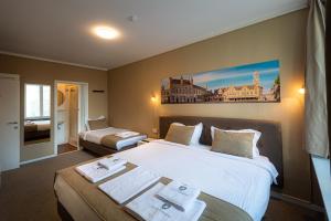 um quarto de hotel com duas camas com toalhas em Hotel Cavalier em Bruges