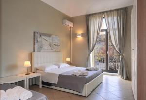 a bedroom with a bed and a large window at Katane Holidays in Catania