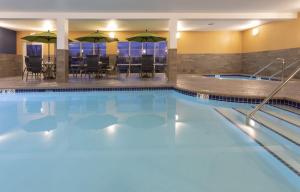 une piscine avec des chaises et des parasols dans un hôtel dans l'établissement Grandstay Hotel Milbank, à Milbank