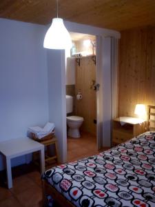 a bedroom with a bed and a bathroom with a toilet at La Casa Antica in Pont-Saint-Martin