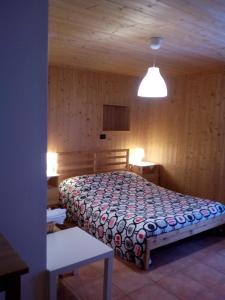ポン・サン・マルタンにあるLa Casa Anticaの木製の部屋にベッド1台が備わるベッドルーム1室があります。