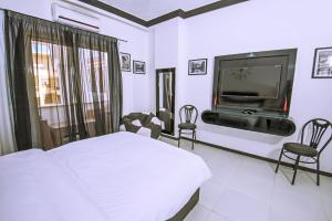 a bedroom with a bed and a flat screen tv at Rare New Marina Hotspot With Fast Free WIFI, Balcony & Pool - Western Standards - Sheraton Plaza 414 in Hurghada